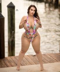 Romi Chase posing almost nude in a monikini and hiding her enormous breasts  and almost nude