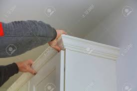 Our trim and molding selections are milled from solid hardwood and are factory finished to match your cabinet paint color. Carpenter Brad Using Nail Gun To Crown Moulding On Kitchen Cabinets Stock Photo Picture And Royalty Free Image Image 89642213