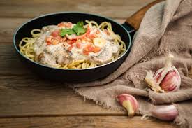 This easy pasta dish is full of savory sausage and a delicious, creamy, parmesan sauce and ready in 20 minutes! Top View Of Composition Of Dry Pasta Rolls Near Bowl With Pesto Sauce And Fresh Basil Leaves With Crushed Garlic And Pine Nuts Near Bottle With Olive Oil Stockphoto