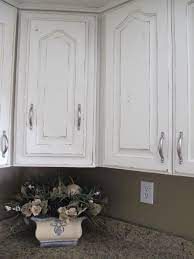 From the sides of the cabinet doors to the edges of the molds, you can scrape the paint a little by using a sand paper to give your cabinet a naturally distressed look. Rachel S Kitchen Makeover Farmhouse Style Kitchen Cabinets Distressed Kitchen Cabinets Kitchen Cabinet Styles