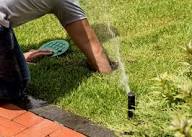 Irrigation repair adjusting sprinkler head and fixing leaks