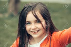 Cette fille aux yeux clairs, qu'elle était à vingt ans. Souriant Visage De Petite Fille Mignonne Heureuse Fille Aux Yeux Bleus Et Closeup Exterieur De Cheveux Brune Sur Fond Vert Flou Banque D Images Et Photos Libres De Droits Image 57488267