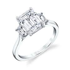 The flower wire basket and milgrain framing add an extra creative touch. Three Stone Emerald Engagement Ring With Emerald Side Stones