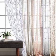 A Line Of Sheer Curtains Hanging Over Floor To Ceiling Windows Next To A Bench Curtains Curtains Living Room Hanging Curtains