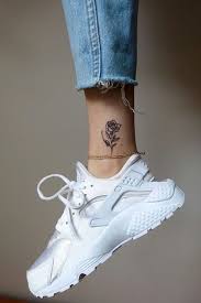 Grey Background Small Tattoo Ideas For Women Jeans White Sneakers Gold Ankle Bracelet Ankle Tattoos For Women Wrist Tattoos For Women Rose Tattoo On Ankle