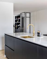 zwart kookeiland met marmerlook en gouden kraan keuken ontwerp gouden keuken keuken interieur