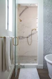 The master bathrooms feature a floating stone double sink with millwork cabinetry in triple layer brushed. Carrera Marble Shower Surround Design Ideas