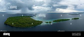 Storm clouds dump rain near a remote tropical island in the Solomon  Islands. This beautiful country is home to spectacular marine biodiversity  Stock Photo - Alamy