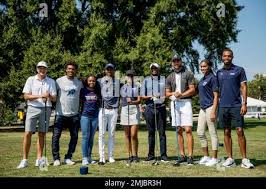 Callaway Golf Company CEO Oliver Brewer III, left, Howard student Otis  Ferguson, fourth from left, Howard University President Wayne Frederick,  fourth from right, and Golden State Warriors guard Stephen Curry, third from