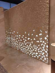 Mosaic Tiles With Some Missing And Lighting Behind Was Stunning At The Porcelanosa Showroom In Valencia Availa Wall Design Wall Cladding Wall And Floor Tiles