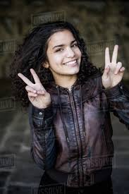 The sides and back are cropped short, with the length. Portrait Of Teenage Girl With Black Curly Hair Showing Peace Sign At Parking Garage Stock Photo Dissolve