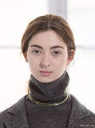 Make a pendant necklace pop by wearing it with a sleeveless sweater in a dark hue. Gold Gold Hoop Necklace Grey Turtleneck Sweater Simple Chic