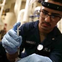 An Iraqi federal police officer searches a detainee