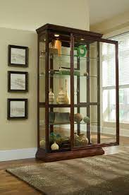 A glass mirrored back enhances the view. 2 Way Sliding Door Curio Cabinet By Pulaski Nis375057182 Missouri Furniture