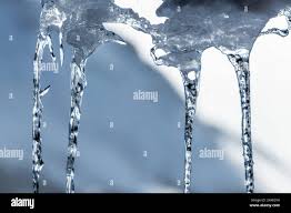 Close up shot view of icicles, ice crystals that have dripped down from a  rooftop in winter, cold freezing season in northern Canada. Blurred  mountain Stock Photo - Alamy