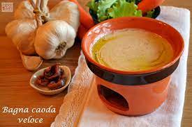 In un tegame di coccio scaldate l'olio, aggiungete gli spicchi sgocciolati e, con un cucchiaio di legno, riduceteli a crema. Bagna Caoda Veloce