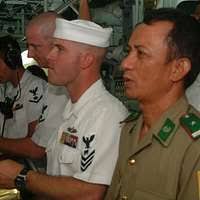 Chief Mineman Maurice Perine, assigned to the mine countermeasures ship USS  Patriot (MCM 7) lets a young Vietnamese child sit in the captain's chair.