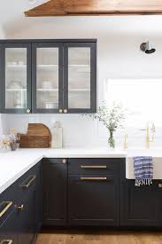 Cabinet hardware is often referred to as the jewelry of a kitchen, and just like with an outfit, it can really alter the overall look of your space. Black Shaker Cabinets With Brushed Gold Pulls And Knobs Transitional Kitchen