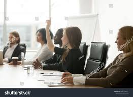 Smiling Curious Young Businesswoman Raising Hand At Multiracial Group Meeting Engaging In Offered Activ Business Training Business Women This Or That Questions