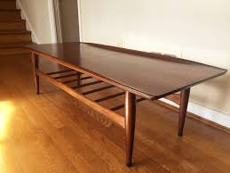 These can be both stylish and functional, as they are a piece that lies at the center of your living room where you set things like coffee, a glass of wine, or a magazine. Mid Century Modern Bassett Artisan Walnut Surfboard Coffee Table Epoch