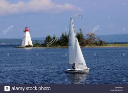 Stock Photo Lighthouse With Sloop Sail Boat Bras D Or Lake Baddeck Cape Breton Nova Scotia Canada Sailing Lighthouse Boat