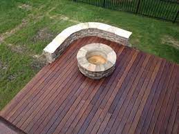 Build your deck around the fire pit, placing stones in patterns, and build a seat wall to match. Fire Features Deck Installation