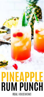 Rum punch in two glasses with cocktail umbrellas and straws. Pineapple Rum Punch Real Housemoms