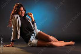 Frau sitzt am Boden und zeigt schöne nackte Beine Stock-Foto | Adobe Stock
