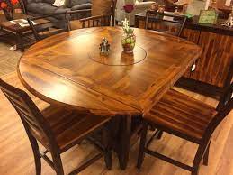 This table features sleek, simple, yet modern lines. Put A Spin On Your Serving Style With A Versatile Lazy Susan Table Which Also Features Handy Drop Leafs That Take T Lazy Susan Table Drop Leaf Table Home Deco