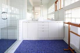 A beige and blue vintage bath rug covers gray bathroom floor tiles. Selling Or Renovating Blue Bathrooms Like These Sell For More Bucks