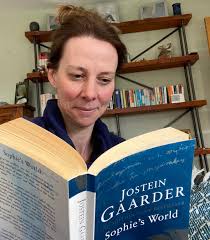 Ms Seymour looks like she is enjoying Sophie's World by Jostein Gaarder. A  nice bookshelf too! #OxtedReadingDay
