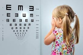 little girl looking at vision test chart stock photo