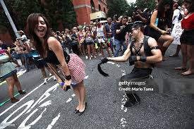 Sarah Riegle is spanked by a reveler during the Gay Pride parade ...
