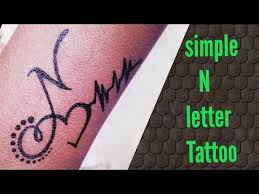 Adding letters, shapes, numbers, flags, color, or strokes also blend in well with a heartbeat tattoo design. N Letter Tattoo By Tattoo By Kk Youtube Tattoo Lettering Alphabet Tattoo Designs Name Tattoo Designs