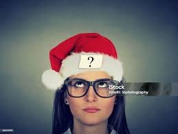 Young Woman In Santa Claus Hat With Question Mark Stock Photo