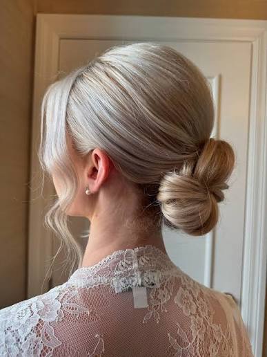 Timeless elegance ✨ This soft, low bridal bun with face-framing tendrils is the perfect choice for brides who want a romantic yet sophisticated wedding hairstyle. The smooth, polished finish and soft texture