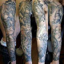 Black ink pirate skull with gun and ship tattoo on man right half sleeve. Top 53 Pirate Tattoo Ideas 2021 Inspiration Guide