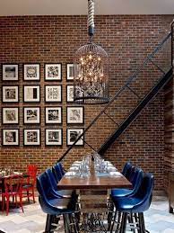 Textured décor accents—a cowhide rug, solid wood table, and leafy foliage centerpiece—infuse the space with some serious farmhouse vibes. 10 Audacious Dining Rooms With Brick Walls Modern Dining Tables Brick Interior Wall Brick Wall Decor Exposed Brick Walls