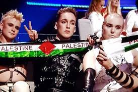 The broadcast quickly panned back to the hosts (image: Iceland S Hatari Holds Up Palestinian Flags At Eurovision 2019 Video Palestine Chronicle