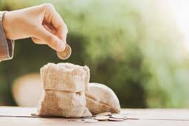 Hand Puting Coins In Money Bag For Saving On Table Background Money Bag Loan Coins