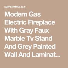 Moderne Gas Elektro Kamin Mit Grauem Faux Marmor Tv Stand Und Grau Lackierter Wand Und Laminatboden Mit Lcd Bildschirm Fur Das Fernsehen Moderne Elektrische Kam Laminatboden Kamin Design Elektrischer Kamin
