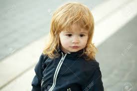 Hairstyles instantly lift up a kid's look and personality so they need a certain measure of thought and creativity. Little Boy With Pretty Cute Face Brown Eyes And Blond Curly Long Hair Stands Outdoor Stock Photo Picture And Royalty Free Image Image 60840324