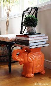 coffee table books stacked on an orange ceramic elephant garden stool act as an end table lulu coffee table books coffee table book stack ceramic elephant
