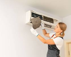 Image of technician holding a clean AC filter next to a dirty one