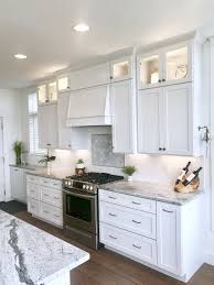 Photo of a small coastal. White Kitchen With Bamboo Wood Floor White Shaker Cabinets White Subway Tile With Arabesque Mar White Shaker Cabinets White Subway Tile Bamboo Wood Flooring