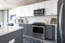 Modern Kitchen With Concrete Ceilings White And Grey Cabinets Stainless Steel Appliances Plank Flooring White An White Kitchen Trendy Kitchen Grey Cabinets