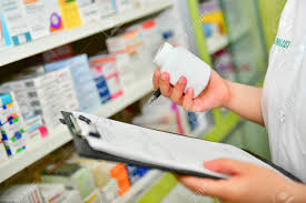Pharmacist Holding Medicine Bottle And Prescription Chart For
