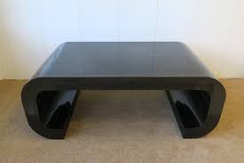 Crafted from manufactured wood with laminate veneers in a rich woodgrain finish, this table strikes a round silhouette with a smooth, thick edge. 70s Modern Black Scroll Coffee Table In The Style Of Karl Springer 1970s At 1stdibs