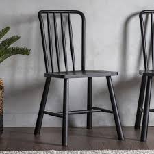 Stylish dining room interior with gray walls, wooden floor, round black and wooden table and chairs, vertical mock up poster and arched window. Wycombe Dining Chair 2pk Wooden Dining Chairs Black Wooden Dining Chairs