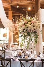A white lantern with candles, a mason jar with burlap and lace, white blooms. Epic Rustic Glam Wedding In Chicago Rustic Glam Wedding Rustic Wedding Centerpieces Flower Centerpieces Wedding
